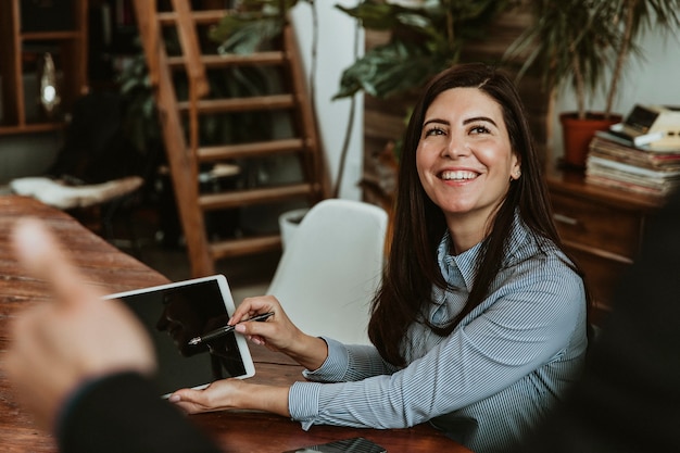 Mujer feliz en una oficina con una maqueta de tableta