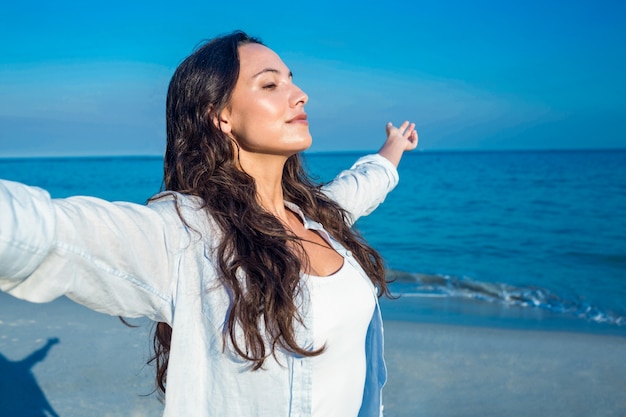 Foto mujer feliz con los ojos cerrados en la playa