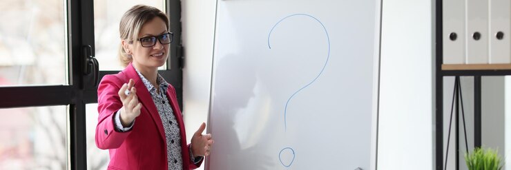 Foto una mujer feliz oradora en una oficina con un marcador cerca de una tabla blanca un concepto de primer plano problema en