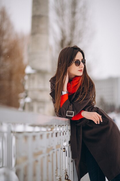 Mujer feliz en pañuelo rojo en invierno afuera