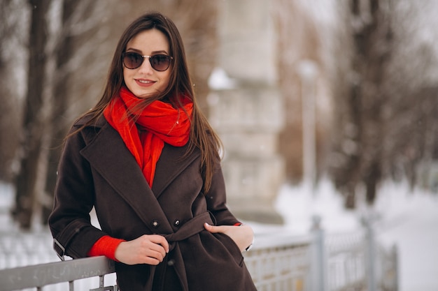Mujer feliz en pañuelo rojo en invierno afuera