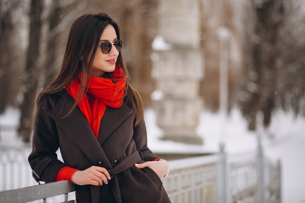 Mujer feliz en pañuelo rojo en invierno afuera