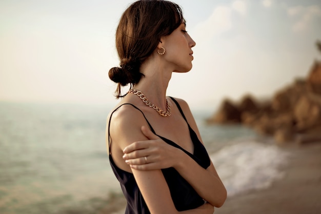 Mujer feliz en la playa caminando junto al mar