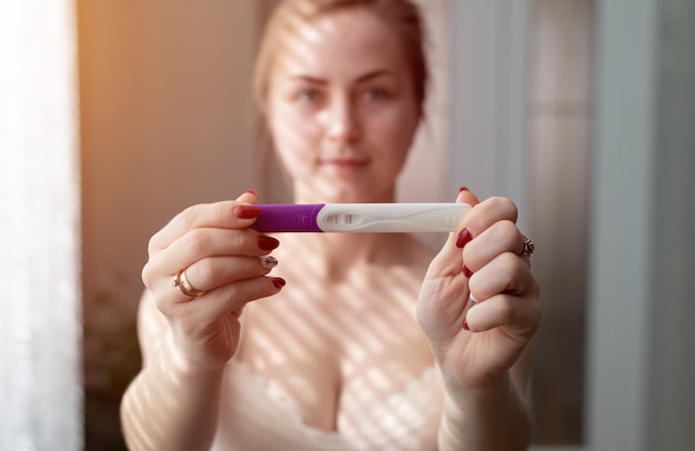 Foto mujer feliz con prueba de embarazo