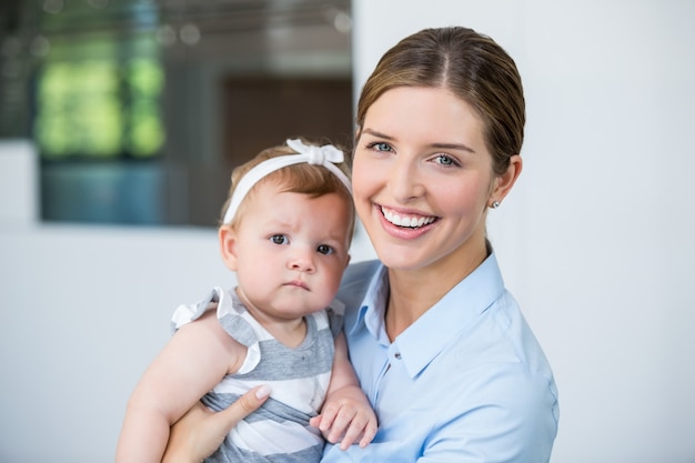 Mujer feliz que lleva a la niña