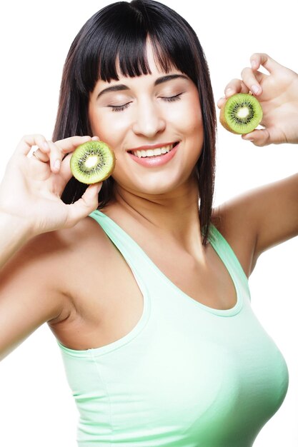 Mujer feliz que sostiene el kiwi