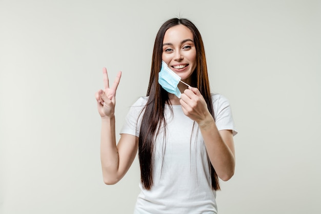 Mujer feliz quitándose la máscara con gesto positivo