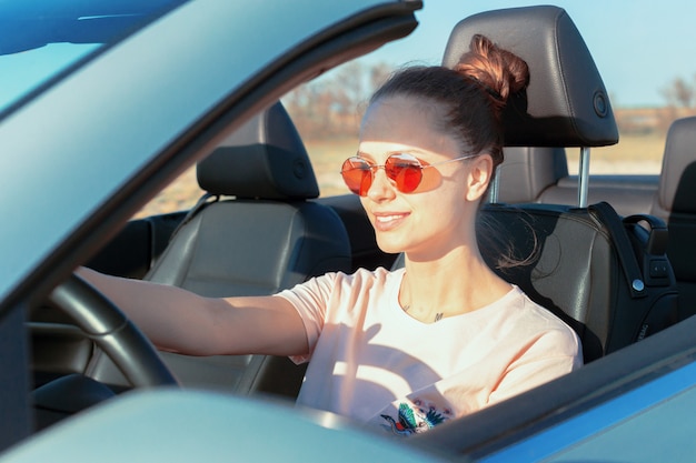 Mujer feliz relajada que viaja en un coche