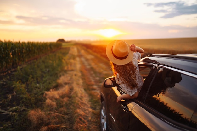 Mujer feliz relajada en verano viaje por carretera viajes vacaciones asomándose por la ventana del coche Estilo de vida