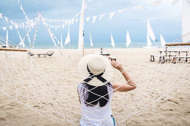 Mujer feliz relajarse en una hamaca en la playa