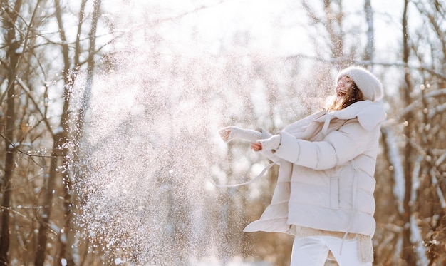 Mujer feliz en ropa de estilo de invierno caminando en el parque nevado Concepto de viaje de vacaciones en la naturaleza