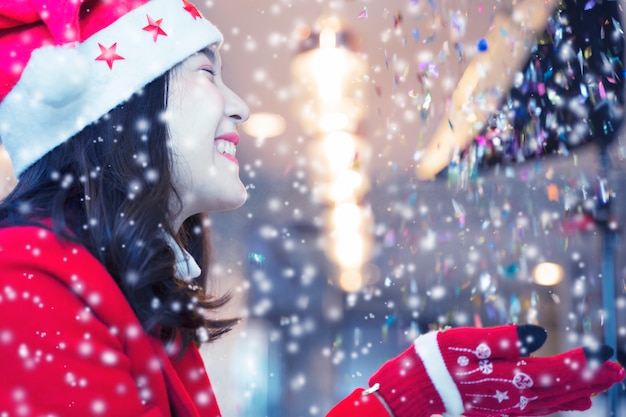 Mujer feliz en ropa de ref con nieve en la noche. Concepto de feliz navidad