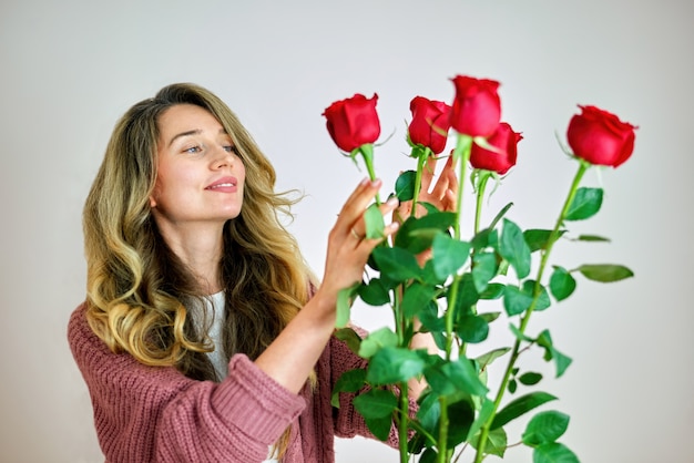 Una mujer feliz con rosas rojas