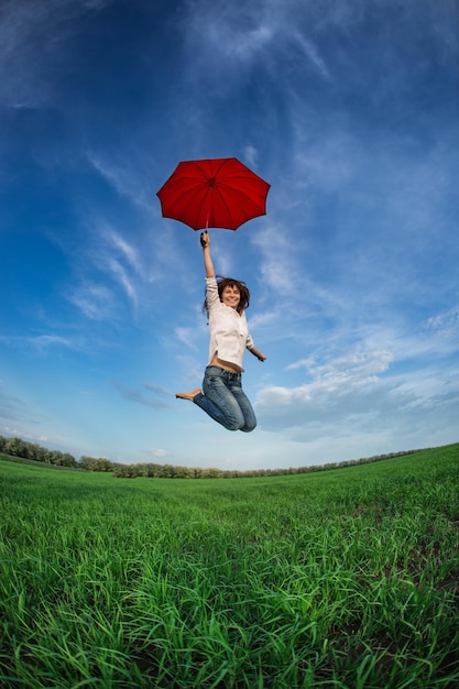 Mujer feliz saltando en el campo de primavera