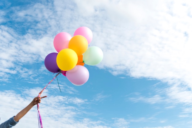 Mujer feliz saltando con globos de aire en el Prado.