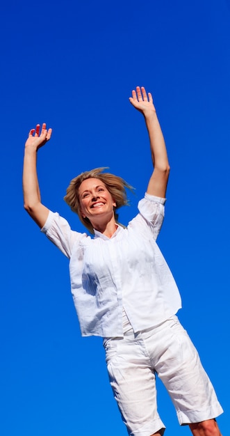 Mujer feliz saltando en un parque