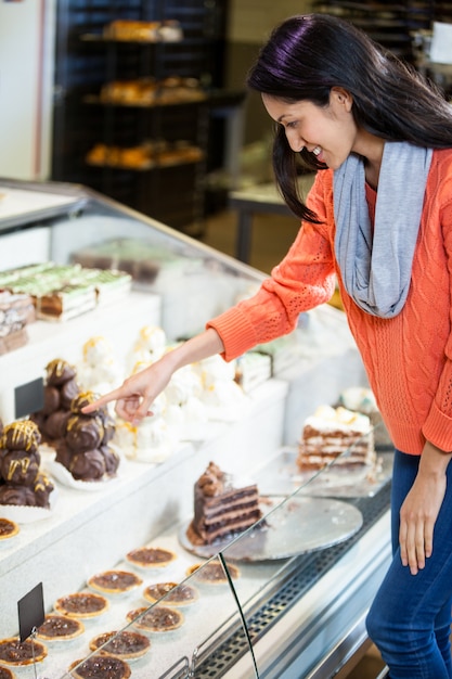 Mujer feliz seleccionando postres