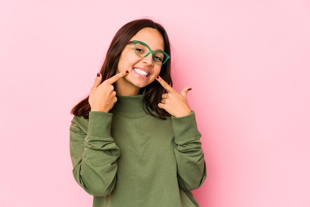 Mujer feliz señalando con el dedo a la sonrisa