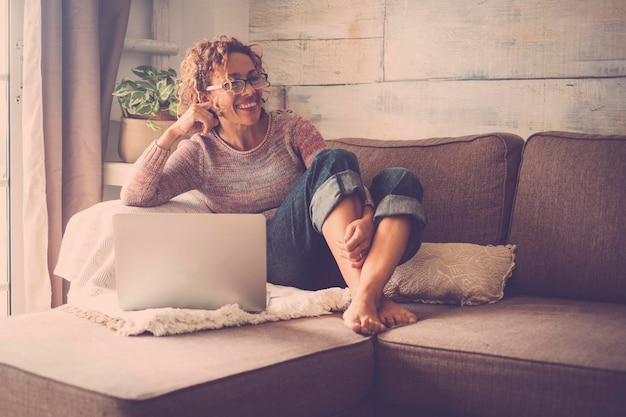 Mujer feliz sentada en el sofá en casa