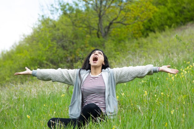 mujer feliz, sentado, en, paisaje