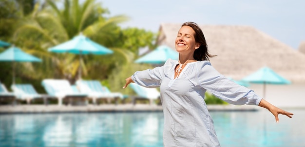 mujer feliz sobre la piscina de un complejo turístico