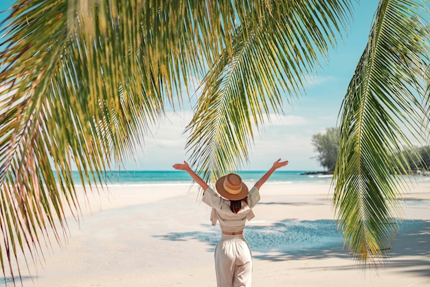 Mujer feliz con sombrero relajándose en la playa y mirando hacia otro lado