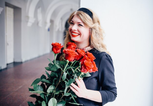 Mujer feliz sorprendida recibe hermoso ramo de flores.