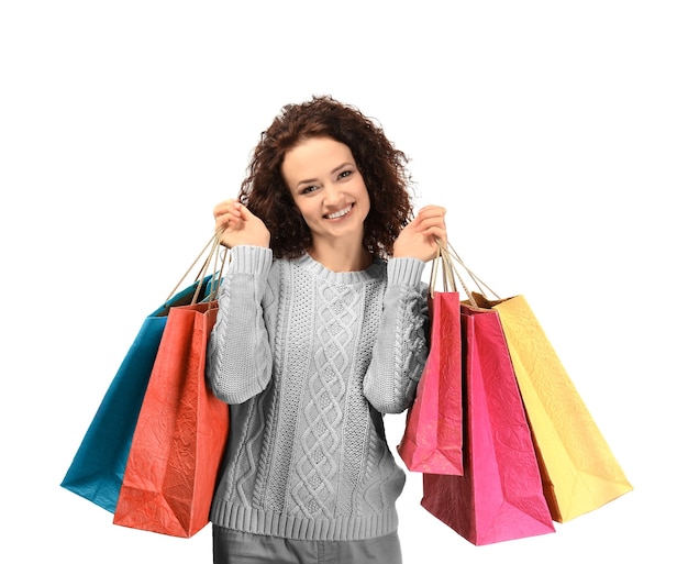 Mujer feliz sosteniendo bolsas de la compra sobre fondo blanco.