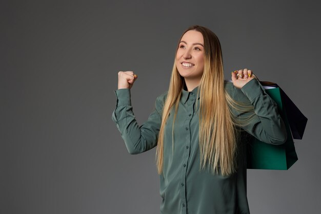 Mujer feliz sosteniendo bolsas de compras con compras