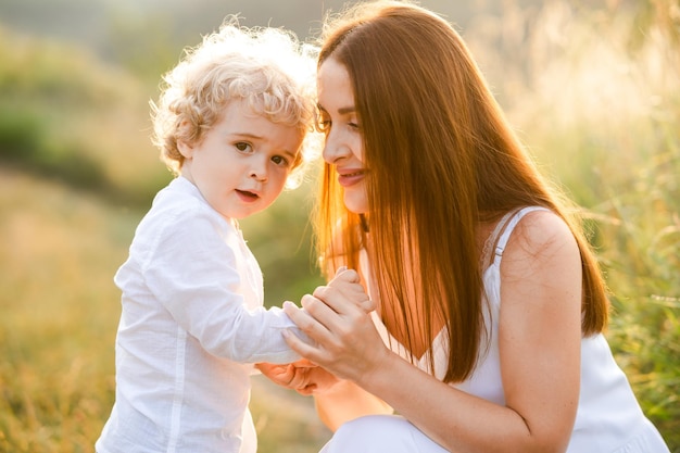 Mujer feliz sosteniendo a su hijo de la mano