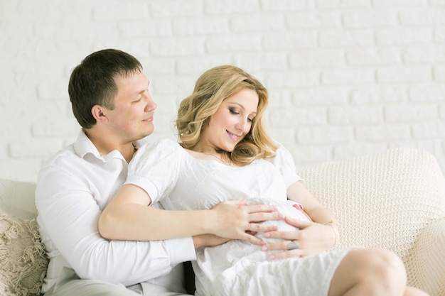 mujer feliz y su amado esposo en casa en el sofá