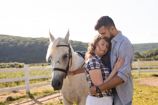 La mujer feliz con su novia parada junto a un caballo.
