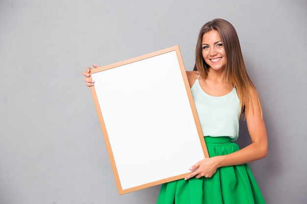 Mujer feliz con tablero en blanco