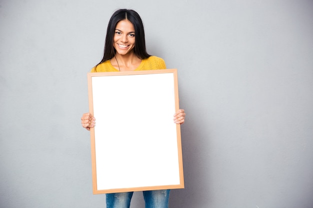 Mujer feliz con tablero en blanco