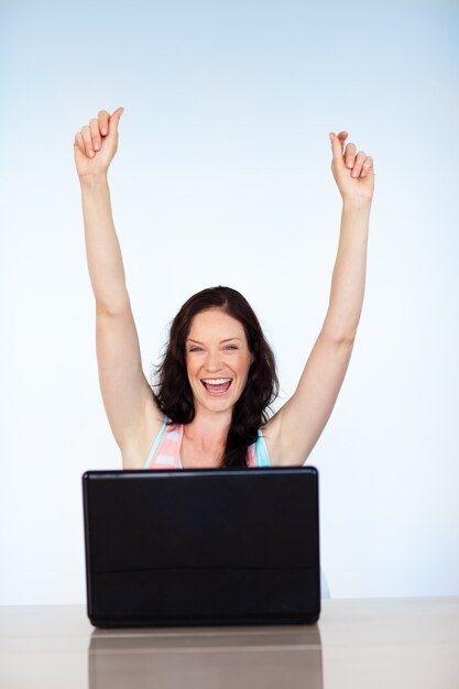 Foto mujer feliz teniendo éxito con la computadora portátil