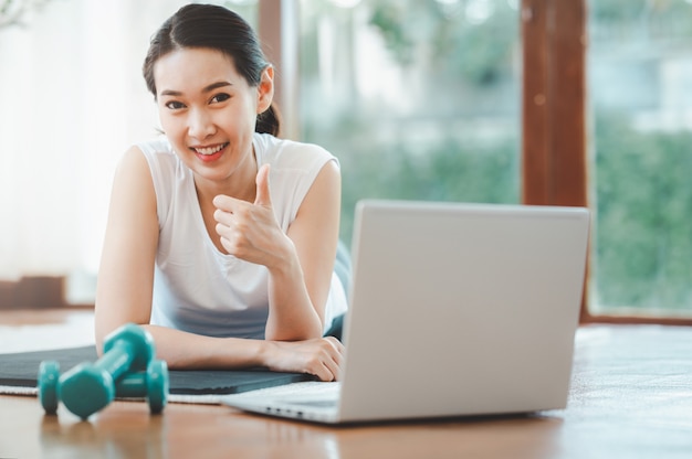 Mujer feliz terminó clase de entrenamiento en línea en casa