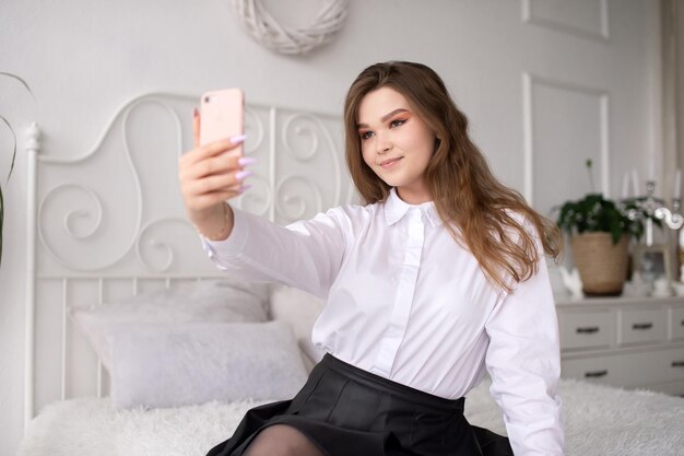 Una mujer feliz tiene una videollamada La niña mira a la cámara del teléfono y sonríe