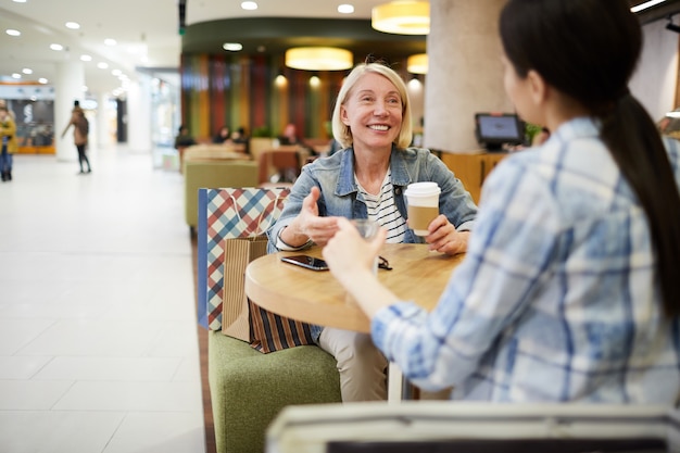 Mujer feliz tomando café con un amigo