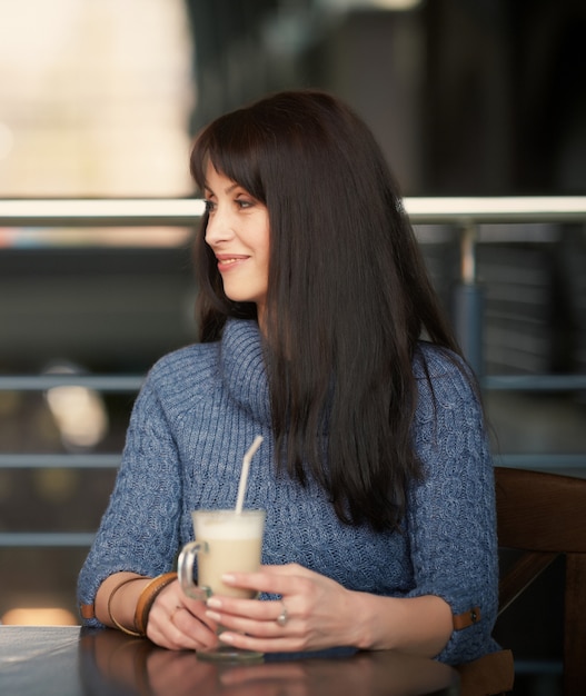 Mujer feliz tomando café en la cafetería