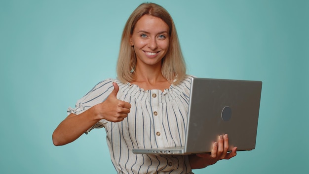 Mujer feliz trabajando en línea en una computadora portátil mostrando el pulgar hacia arriba comentarios positivos como ganar la lotería buena oferta