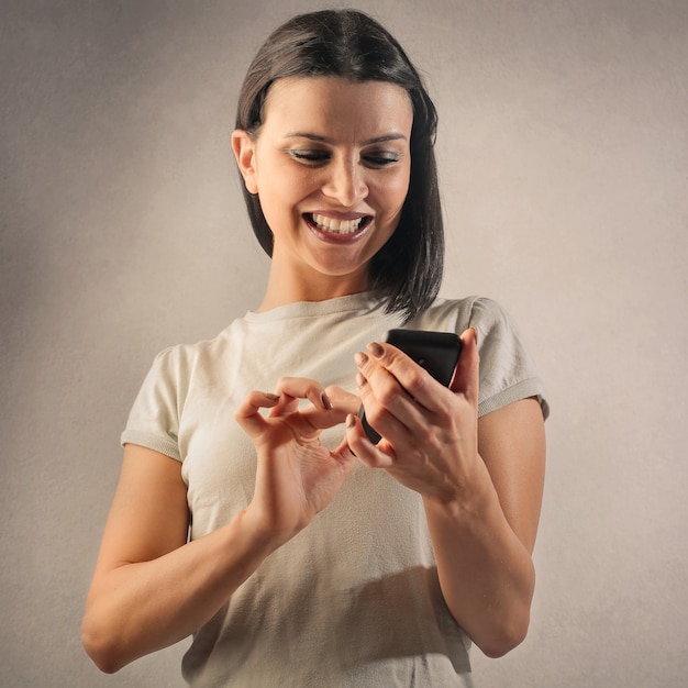 Mujer feliz usando un teléfono inteligente