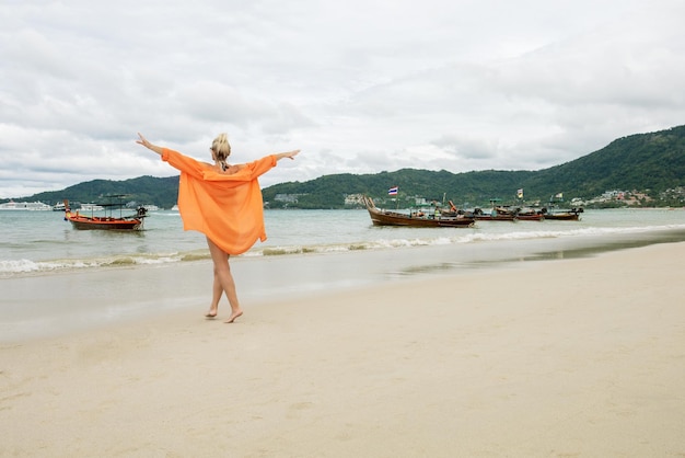 Mujer feliz en vestido bailando en la playa en vacaciones de verano vitalidad concepto de vida saludable vacaciones de vacaciones en Tailandia