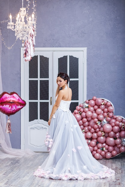 Foto mujer feliz en vestido de tul con globos de color rosa. lujo