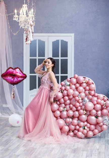 Mujer feliz en vestido de tul con globos de color rosa. lujo