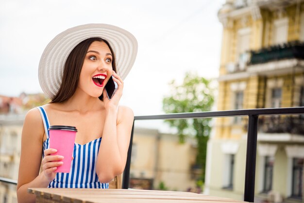 Mujer feliz en vestido de verano posando con sombrero de paja