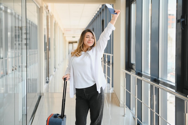 Foto mujer feliz viajando y caminando en el aeropuerto