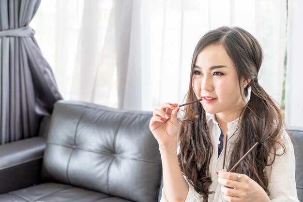 Mujer feliz viendo televisión con merienda