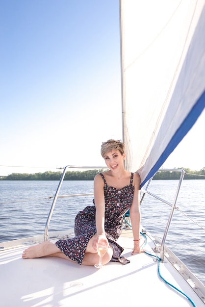 Mujer feliz en un yate junto al mar