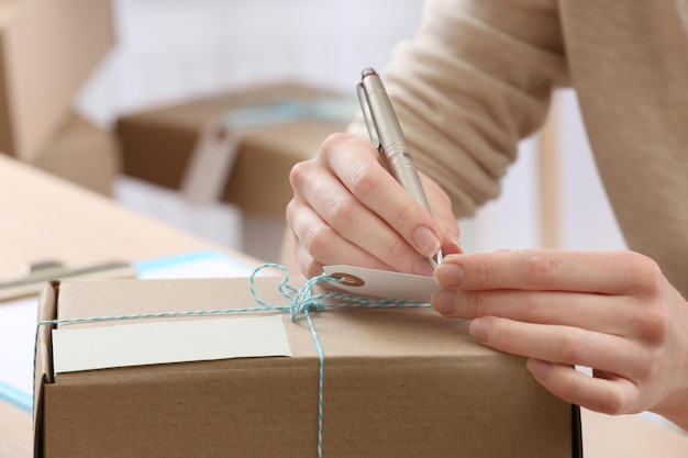 Mujer firma paquete en oficina de correos