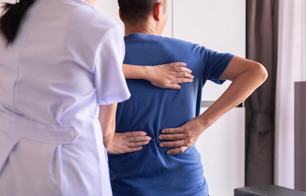 Mujer fisioterapeuta haciendo tratamiento al paciente hombre en la clínica, concepto de fisioterapia